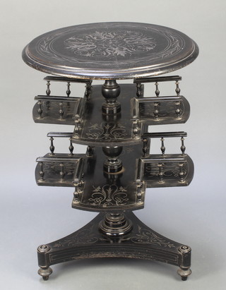 An Edwardian carved and ebonised circular revolving table on a turned column and triform base with bun feet 30"h x 21 1/2" diam. 