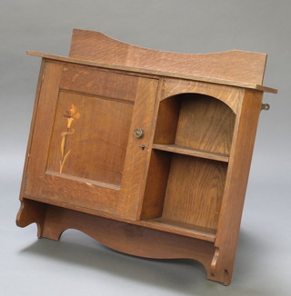 An Edwardian Art Nouveau inlaid oak hanging cabinet with raised back fitted a recess to 1 side with cupboard enclosed by panelled door 25" x 28 1/2" x 8" 