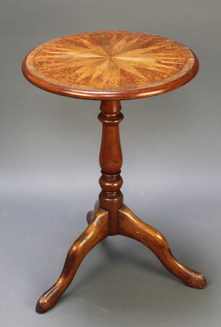 A circular Victorian figured walnut and marquetry wine table, the crossbanded top decorated a stylised star, raised on an associated pillar and tripod base 29"h x 20" diam. 