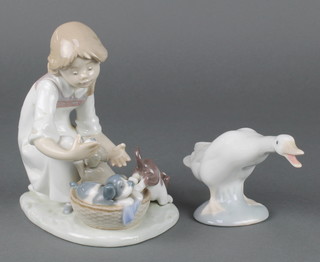 A Lladro figure group of a girl with a basket of puppies 5595 6" together with a ditto figure of a goose 4" 