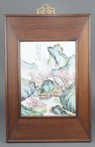 A 20th Century Chinese painted porcelain panel depicting an extensive mountainous landscape with figures in pavilions with script 12" x 8 3/4" contained in a hardwood frame