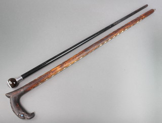 An ebony cane with polished hardstone terminal together with an "American" hardwood cane inlaid mother of pearl the handle in the form of an eagles head  