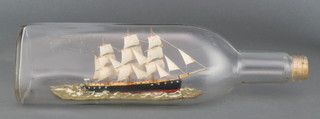 A 3 masted ship in bottle, contained in a W M Grants & Sons whisky bottle 4"h x 11"l x 3"d 
