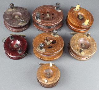 A 5" wooden and brass star back fishing reel and 6 other wooden centre pin fishing reels