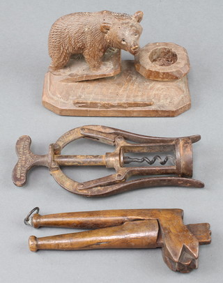A pair of 19th Century naive wooden nut crackers with scratched decoration 6", a Swiss carved pipe stand in the form of a standing bear 3" (some old holes to the body,) together with a James Heeley & Sons patent corkscrew 