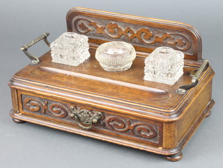 An Edwardian carved oak twin bottle inkstand with raised carved back fitted 2 inkwells and a glass jar with pen recess above 1 long drawer, raised on bun feet 7"h x 13"w x 8"d 