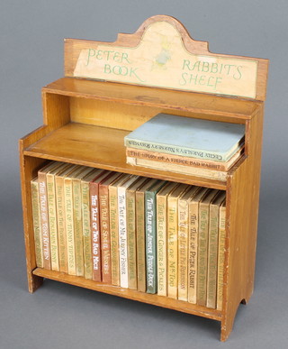24 volumes of Beatrix Potter contained in a wooden bookcase (2 editions of Jeremy Fisher and Miss Moppet missing spine) 