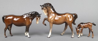 A Beswick figure of a standing horse with head turning right 8 1/2", a ditto with front right leg raised 7 1/2" and a ditto foal with head down 3" 