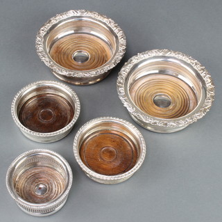A pair of silver plated coasters with floral decoration 6", a smaller pair and 1 odd ditto 