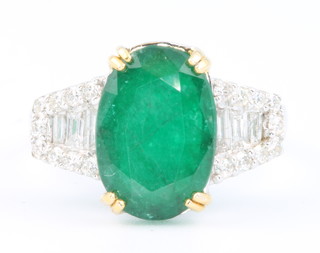 An 18ct white gold oval emerald and diamond ring, the centre stone approx 3.7ct, the diamonds 0.46ct, size M 1/2