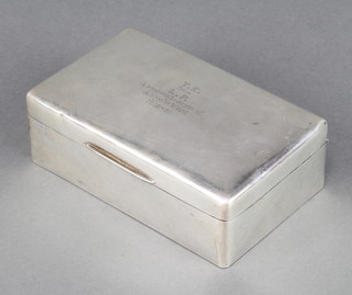 A rectangular silver cigarette box with presentation inscription London 1921 6" x 3 1/2" 