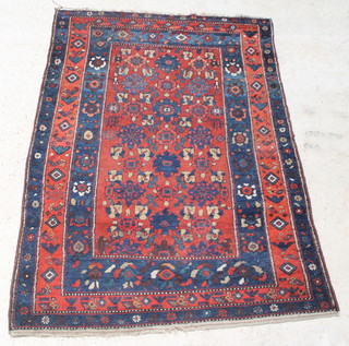 A red ground and floral patterned Persian rug with multi-row borders 77" x 53" 