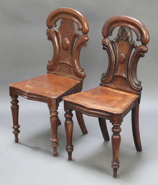 A matched pair of Victorian mahogany hall chairs with pierced back and shaped seats raised on turned supports 