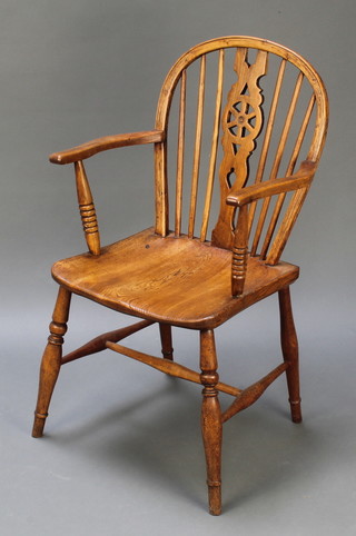 A light elm wheelback carver chair with solid seat, turned supports and H framed stretcher
