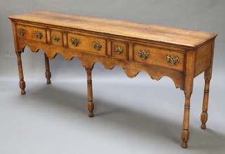 A 17th Century style light elm dresser base fitted 3 long and 2 short drawers with wavy apron, raised on 5 turned and block supports 30"h x 71 1/2"w x 14"d 