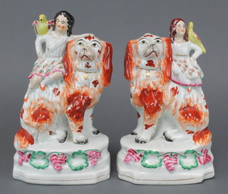 A pair of Victorian Staffordshire groups of children on giant spaniels 10" 