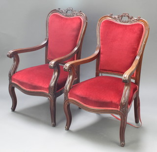 A pair of Victorian mahogany show frame armchairs upholstered in red material, raised on cabriole supports