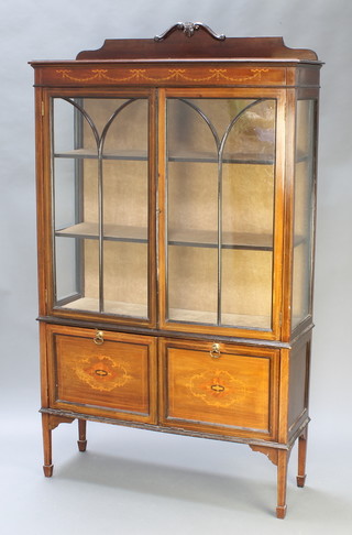 An Edwardian inlaid mahogany display cabinet with raised back, the interior with plush lining enclosed by astragal glazed doors and having a fall front fitted pigeon holes and sheet music rack, raised on square tapering supports, spade feet 70"h x 41"w x 13"d 