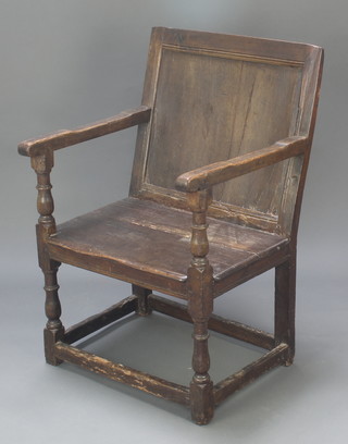 A 17th/18th Century oak Wainscot chair of panelled construction, raised on turned and block supports with box framed stretcher 