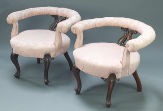 A pair of Victorian rosewood hoop back bedroom chairs upholstered in pink material, raised on cabriole supports 