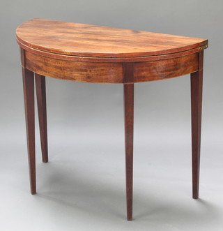 A Georgian mahogany demi-lune card table raised on square tapered supports 29"h x 35 1/2"w x 17 1/2"d 