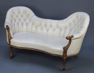 A Victorian carved walnut show frame settee, upholstered in white buttoned back "leather" material, raised on cabriole supports 32"h x 59"w x 29"d 