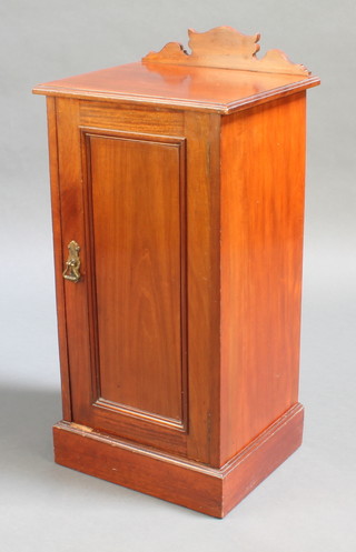 An Edwardian walnut pot cupboard with raised back enclosed by a panelled door with brass handle, raised on a platform base 33 1/2"h x 16" x 14"  