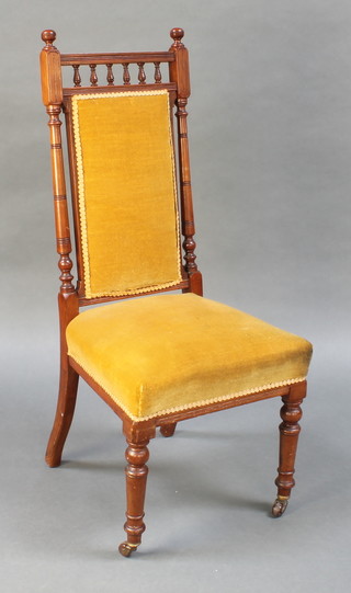 A Victorian walnut show frame nursing chair with bobbin turned decoration upholstered in mushroom coloured material, raised on turned supports 