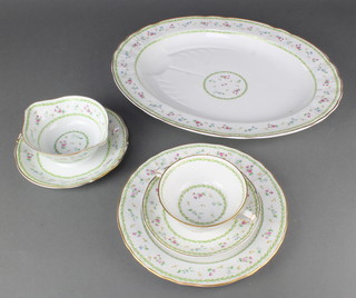 A Limoges Artois pattern dinner service comprising 10 two handled bowls, 10  saucers, 4 small plates, 22 dinner plates, a sauce boat and an oval meat plate