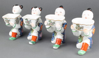 A pair of modern Chinese table salts in the form of 4 kneeling boys holding rectangular bowls 5 1/2" 