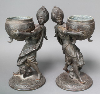 A pair of Victorian spelter jardinieres in the form of standing liveried servants raised on a circular base 16" x 9" 
