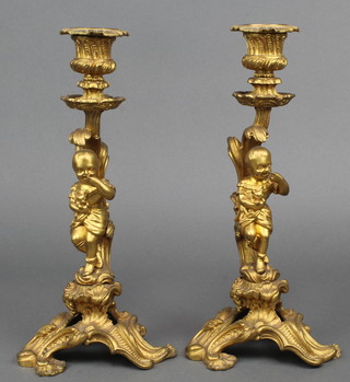 A pair of 19th Century gilt ormolu candlesticks in the form of standing girls with kittens, having detachable sconces 10 1/2"