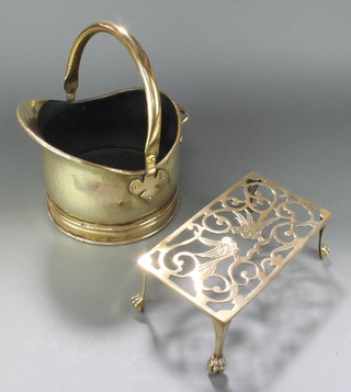 A polished brass helmet shaped coal scuttle with swing handle and a pierced polished brass footman decorated birds 4" x 10" x 6" 