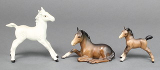 A Beswick figure of a standing dappled foal 5 1/2", a ditto of a reclining horse 5" and another of a standing brown foal 4" 