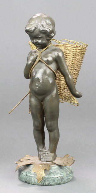 A metal figure of a cherub carrying a wire work basket, raised on a green marble socle base 8" 