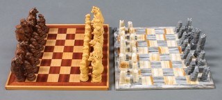 A carved onyx chess set complete with board, together with a resin chess set the pieces  in the form of mythical beasts complete with wooden board
