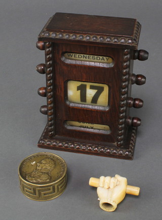 A Victorian carved ivory parasol handle in the form of a clenched fist 1 1/2 " and a cylindrical repousse brass Nelson memorial box 1' x 2" and an oak perpetual desk calendar 6" x 4 1/2" x 2 1/2"