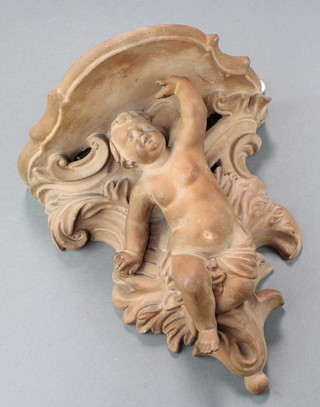 A Continental pottery wall bracket decorated in the Rococo style with a cherub 