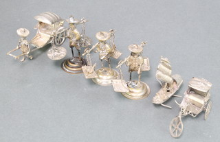 A silver figure of a man with rickshaw and other figures