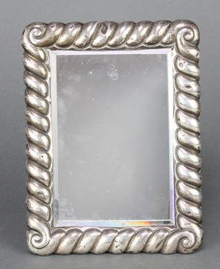 An Edwardian repousse silver rectangular photograph frame with scroll decoration 8 1/2" x 6", rubbed marks 