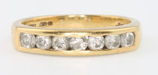 An 18ct yellow gold channel set 7 stone diamond ring, size J 