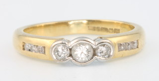An 18ct yellow gold 3 stone diamond ring with 3 diamonds to each shoulder, size I  1/2, 3 grams 