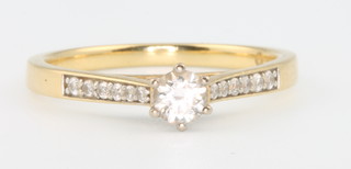 An 18ct yellow gold single stone diamond ring with diamond shoulders, size N