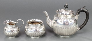 A Victorian repousse silver bachelor's 3 piece tea set with demi-fluted decoration and ebony mounts Birmingham 1888, gross weight 478 grams 
