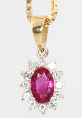 An 18ct yellow gold ruby and diamond oval pendant on a ditto chain 
