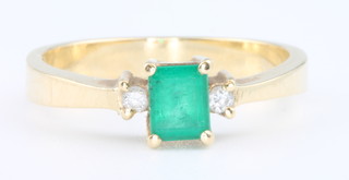 A 15ct yellow gold baguette cut emerald and diamond ring, size N 