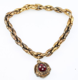 An Edwardian 15ct yellow gold bracelet set with a charm having a cabochon cut garnet, with box 