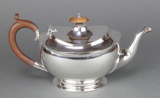 An oval silver teapot with fruitwood mounts Birmingham 1925, gross weight of 610 grams 