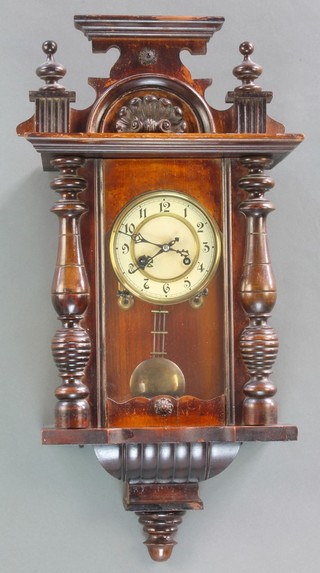 A Vienna style regulator with paper dial and Arabic numerals with grid iron pendulum contained in a carved case 