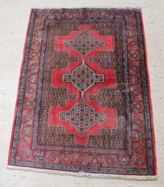 A Persian Senneh red ground rug with 3 stylised medallions to the centre 67" x 49 1/2" 